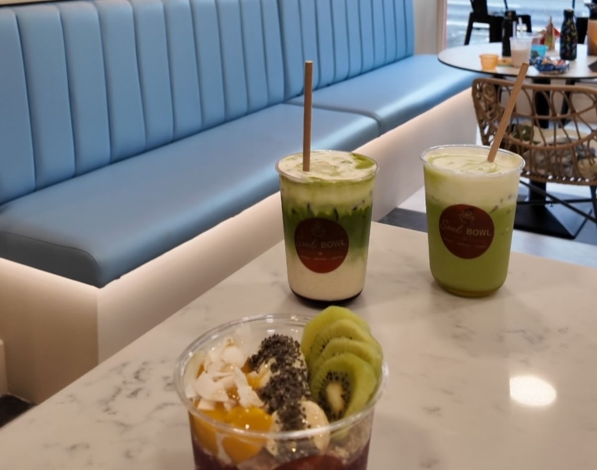 Inside Soul Bowl - drinks and a bowl on a table by the blue banquette